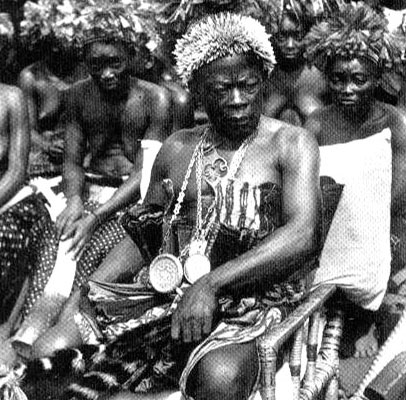 Chef tribal Karume On remarquera sa plaque ronde en sautoir attribuée par l'Administration coloniale. Il est le seul à pouvoir être assis, à porter une coiffe de chef et à manipuler un chasse-mouche en guise de signe d'autorité. Il porte une parure en porte de léopard et est entouré de ses femmes.
