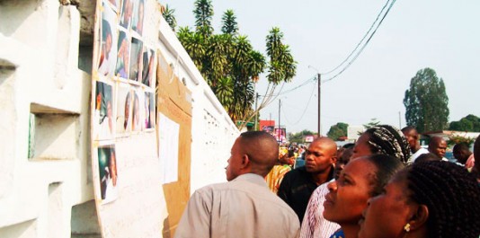Les gens regardent des photos de victimes blessées devant l'hôpital de Loandjili à Pointe-Noire le 22 Juin 2010. - Photo: AFP.