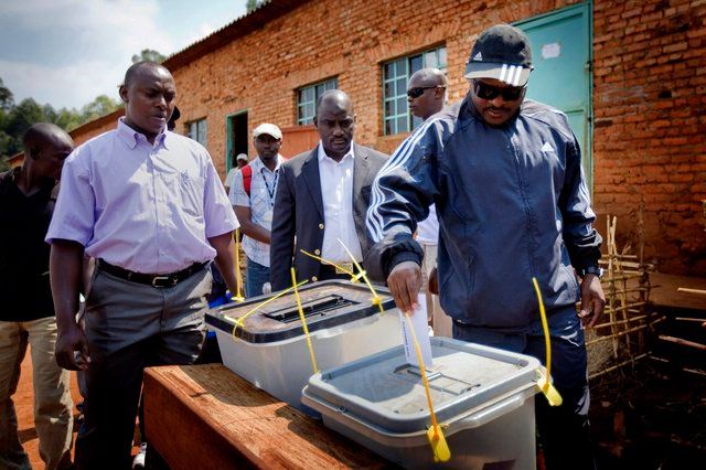 Le président burundais Pierre Nkurunziza, à droite, exprime son vote à un bureau de vote dans sa ville natale de Mumba dans la province de Ngozi, au nord du Burundi. Après que tous les partis de l'opposition se sont retiré de la course, les électeurs ont le choix entre le parti au pouvoir CNDD-FDD ou de déclarer leurs votes nuls. (AP Photo / Sylvain Liechti)