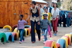 Michelle Obama marche avec les enfants lors de sa visite du Centre communautaire Emthonjeni situé à Zandspruit en Afrique du Sud, mardi, le 21 juin 2011