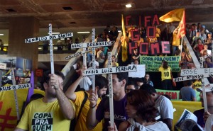 Les manifestants portant des croix avec les noms des personnes tuées lors de la rénovation des stades prennent part à une manifestation contre la prochaine Coupe du Monde 2014 au Brésil lors de la « Journée internationale de la Résistance Coupe du Monde » à São Paulo, Brésil, le 15 mai 2014. – Photo : Getty Images