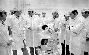 Au centre George R. Carruthers, principal chercheur de la caméra-spectrographe discute de l'instrument avec le commandant d’Apollo 16 John Young à droite, et directeur du programme Apollo Rocco Petrone, à gauche.